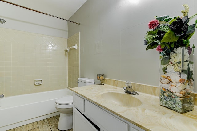 full bathroom featuring hardwood / wood-style flooring, vanity, tiled shower / bath combo, and toilet