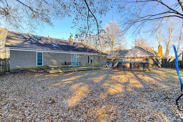 back of house with a pool side deck