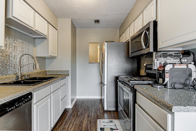 kitchen featuring dark hardwood / wood-style flooring, white cabinets, stainless steel appliances, and sink