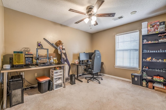 carpeted home office featuring ceiling fan and a textured ceiling