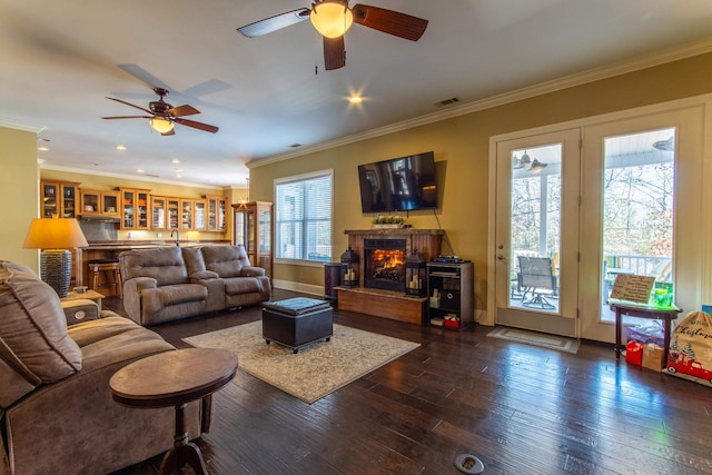 living room with dark hardwood / wood-style flooring, ceiling fan, and crown molding