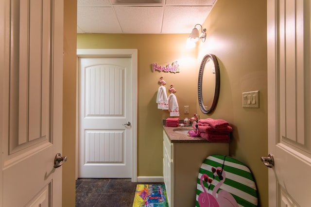 bathroom with tile patterned flooring, vanity, and a drop ceiling