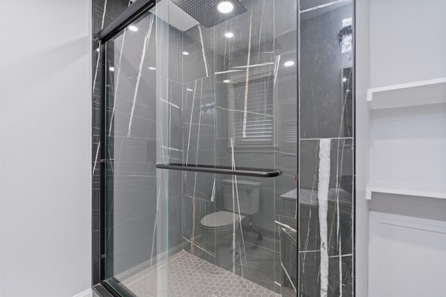 bathroom with tile patterned floors, a shower with shower door, and toilet