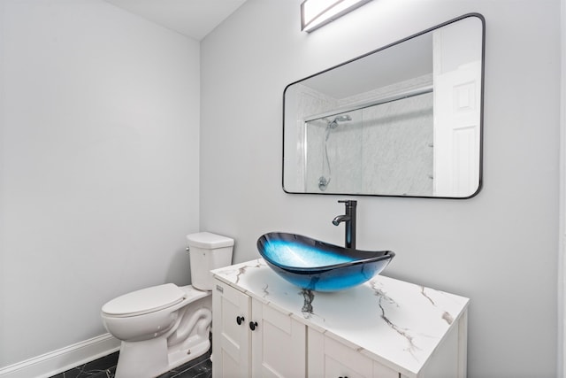 bathroom featuring tile patterned flooring, toilet, vanity, and walk in shower