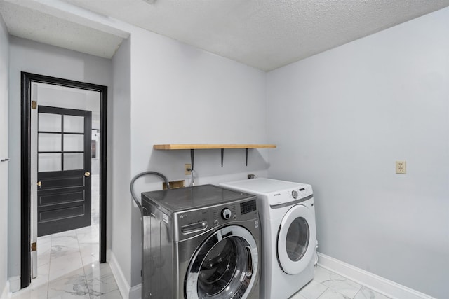 washroom featuring washing machine and clothes dryer and a textured ceiling