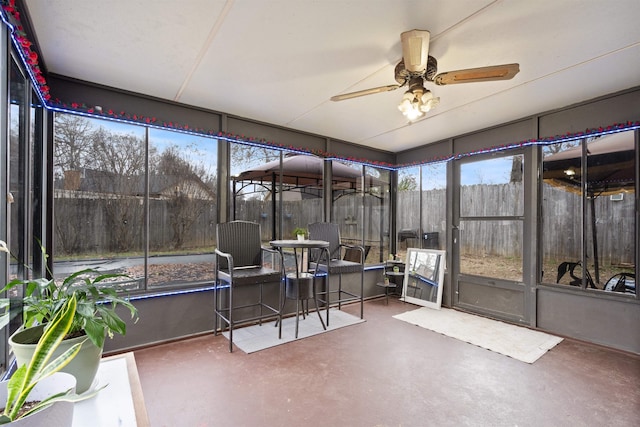 sunroom / solarium featuring ceiling fan