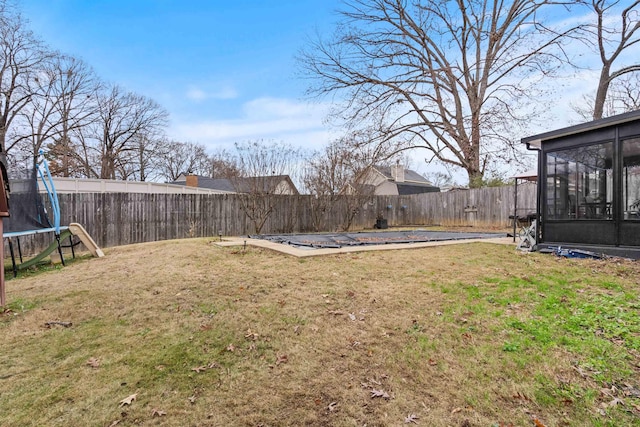 view of yard with a sunroom, a pool, and a trampoline