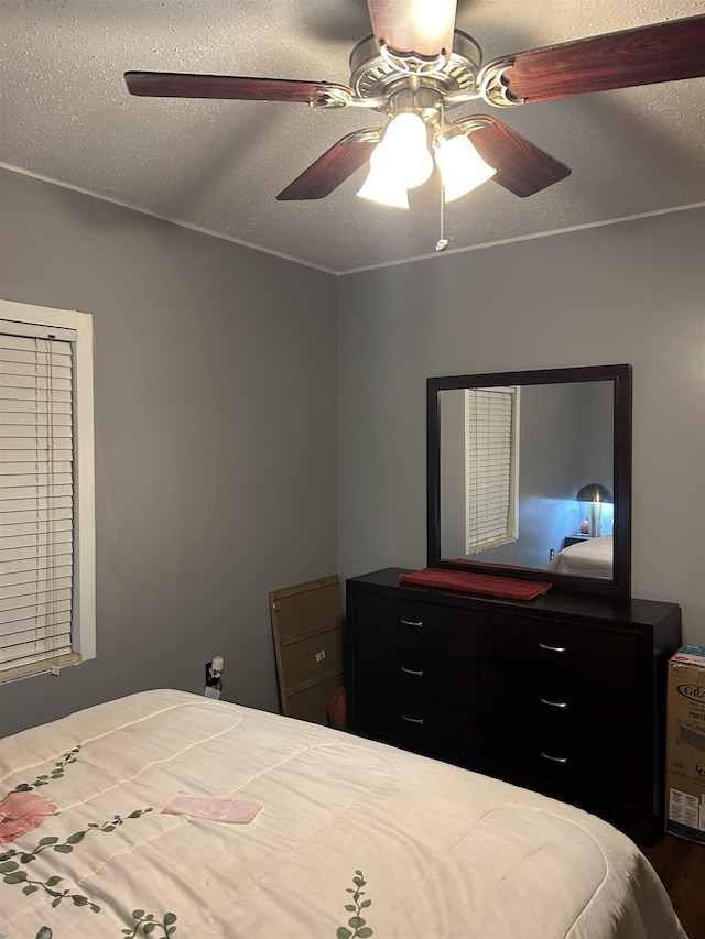 bedroom with ceiling fan, hardwood / wood-style floors, and a textured ceiling