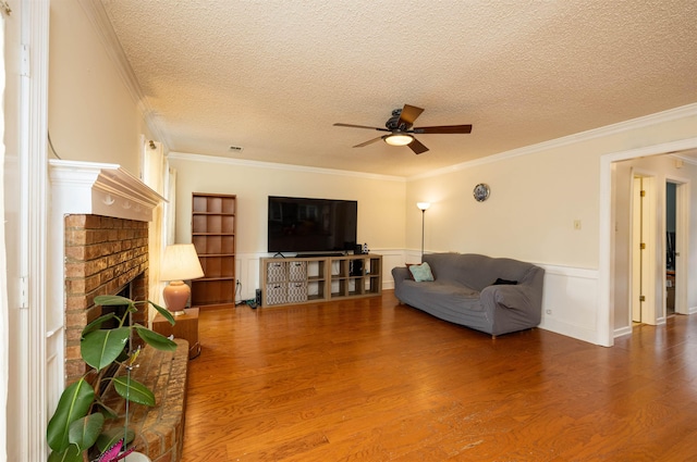 living room featuring hardwood / wood-style flooring, ornamental molding, and a textured ceiling