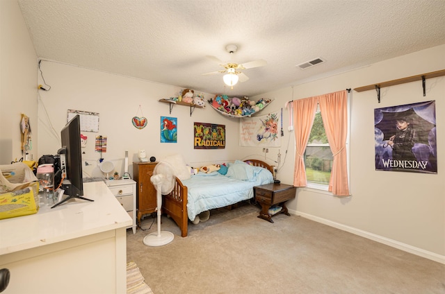 carpeted bedroom with ceiling fan and a textured ceiling