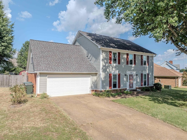 colonial home featuring a garage and a front lawn