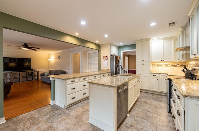 kitchen with light stone counters, appliances with stainless steel finishes, sink, and a kitchen island