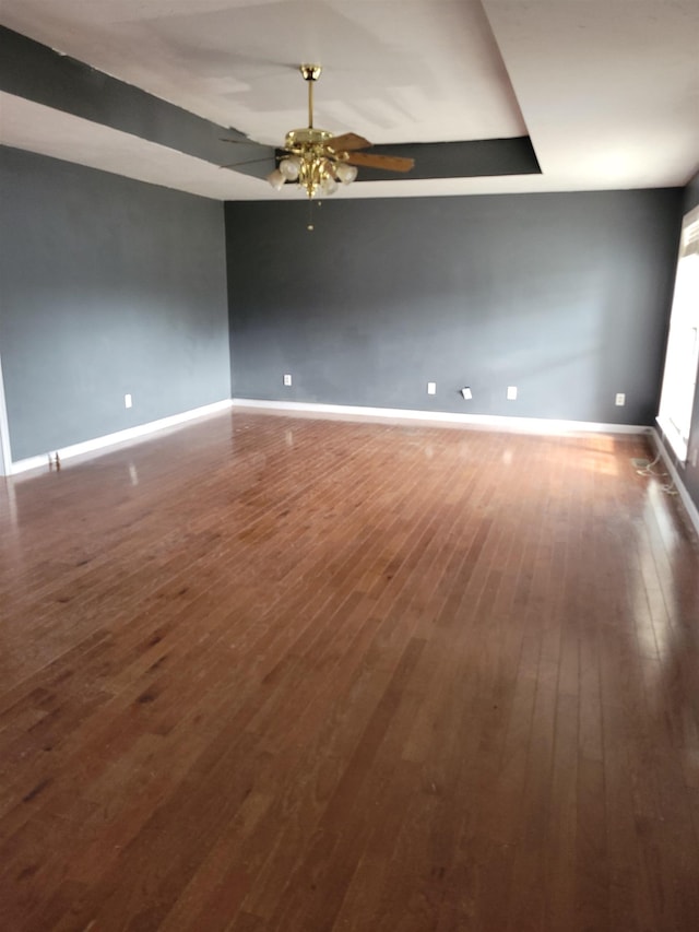 empty room with ceiling fan and dark wood-type flooring