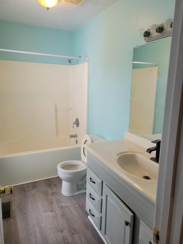 full bathroom with wood-type flooring, vanity,  shower combination, and toilet