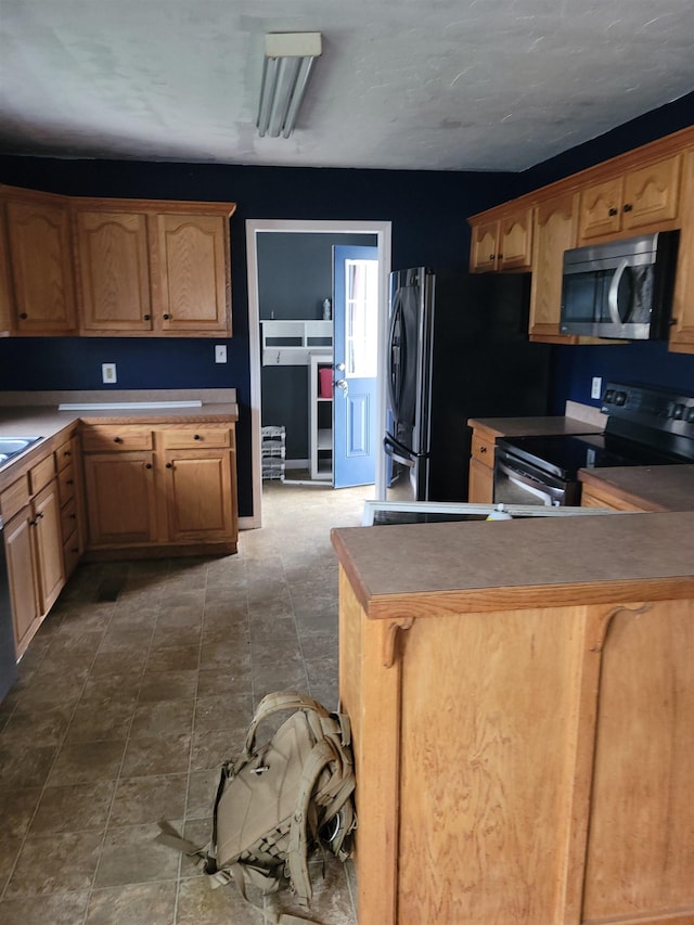 kitchen featuring black range with electric stovetop, fridge, and kitchen peninsula