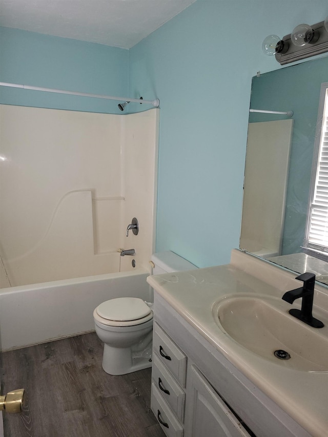 full bathroom with hardwood / wood-style flooring, toilet, vanity, and  shower combination