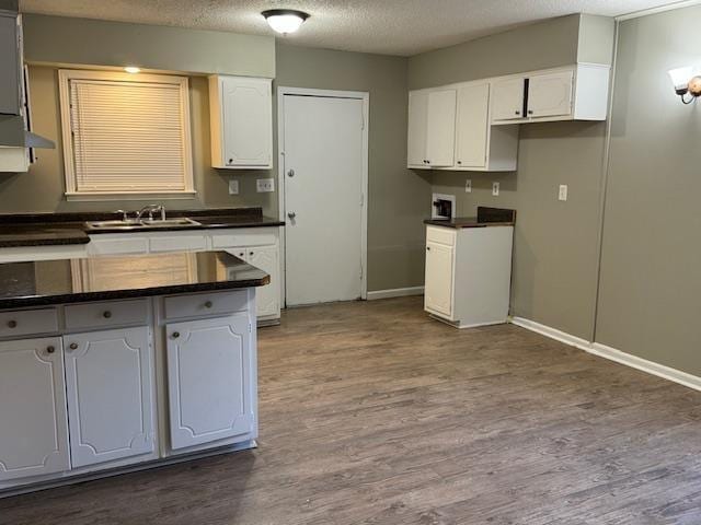 3245 Sinclair Dr, Memphis, TN 38127 - kitchen featuring dark countertops, white cabinets, dark wood finished floors, and a textured ceiling