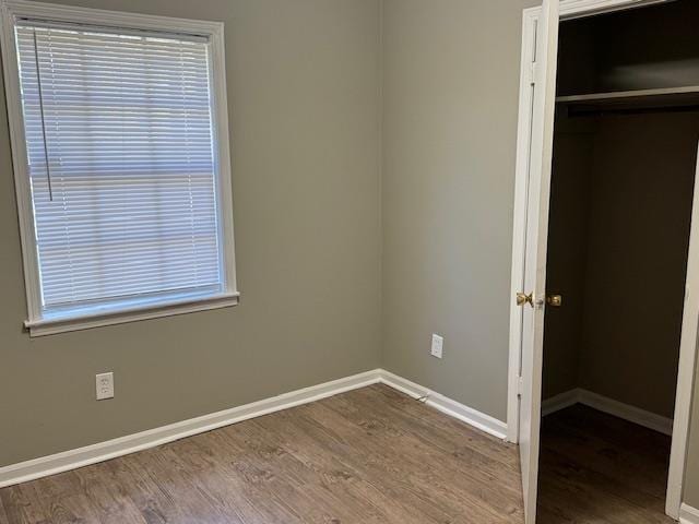 unfurnished bedroom featuring a closet and wood-type flooring