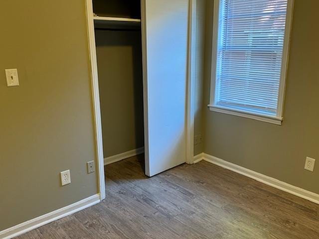 unfurnished bedroom featuring hardwood / wood-style flooring and a closet