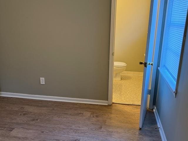 bathroom featuring toilet and wood-type flooring