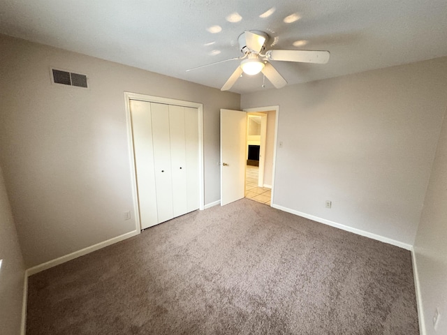 unfurnished bedroom with carpet floors, a closet, and ceiling fan