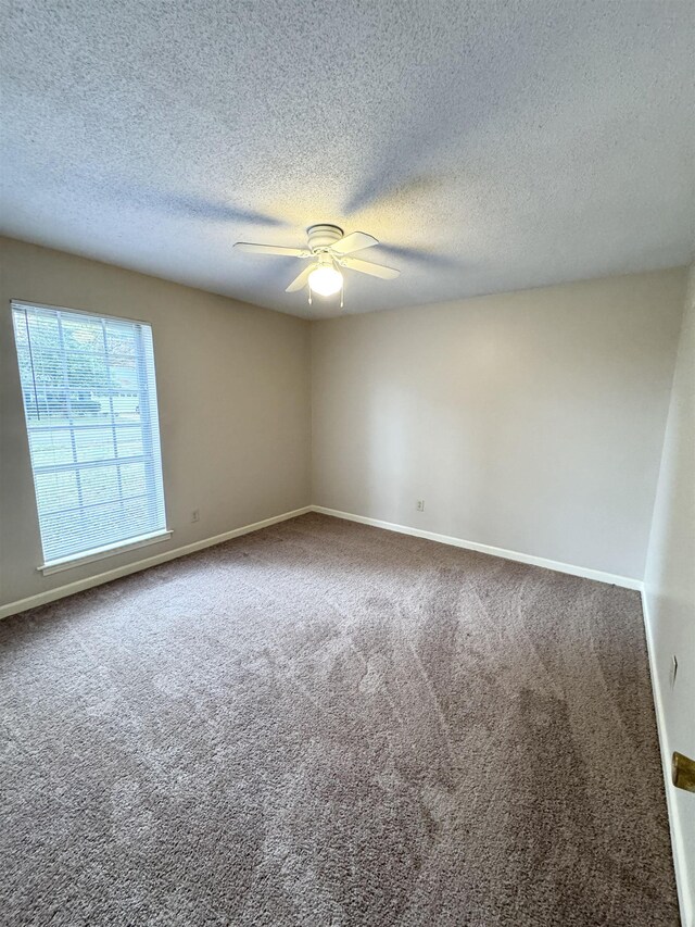 empty room featuring carpet, a textured ceiling, and ceiling fan