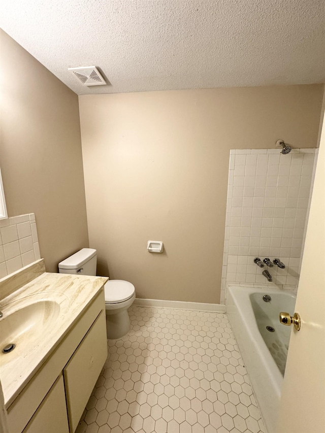 bathroom with vanity, tile patterned flooring, a washtub, toilet, and a textured ceiling