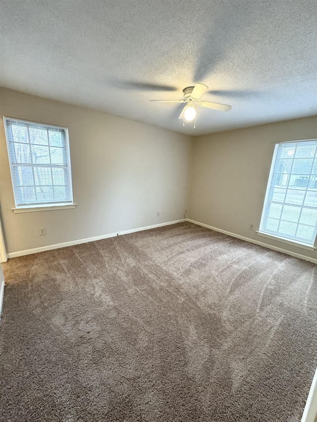 spare room featuring ceiling fan, carpet floors, and a textured ceiling