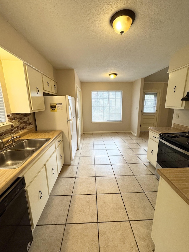 kitchen with sink, light tile patterned floors, tasteful backsplash, white cabinets, and black appliances