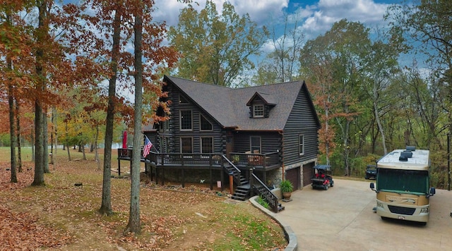 log home featuring a deck and a garage