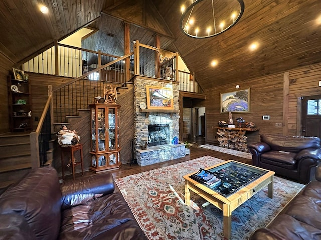 living room with wooden ceiling, high vaulted ceiling, wood walls, a fireplace, and hardwood / wood-style flooring