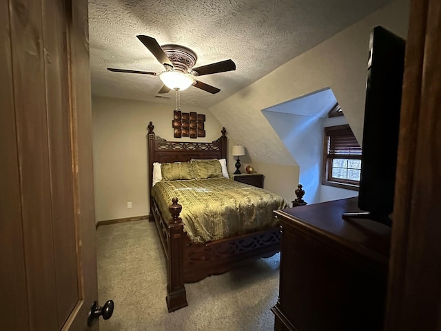 bedroom with ceiling fan, light colored carpet, a textured ceiling, and vaulted ceiling