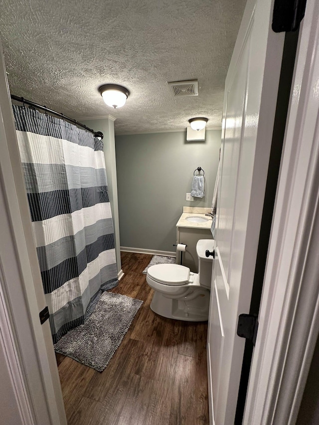 bathroom featuring hardwood / wood-style flooring, vanity, toilet, and a textured ceiling