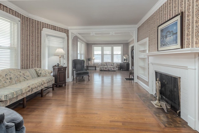 living room featuring hardwood / wood-style floors, built in shelves, and ornamental molding