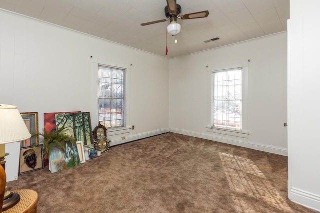 spare room with plenty of natural light, ceiling fan, carpet floors, and ornamental molding