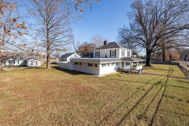 back of property with a lawn and a storage shed