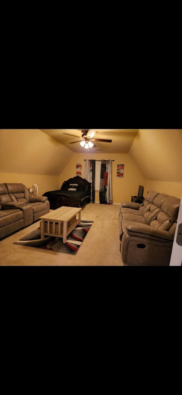 cinema room featuring carpet flooring, ceiling fan, and vaulted ceiling