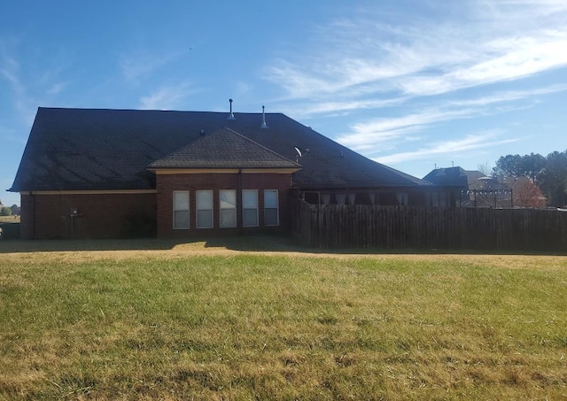 rear view of house featuring a yard