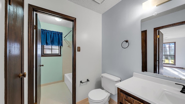 bathroom with vanity, toilet, and a textured ceiling