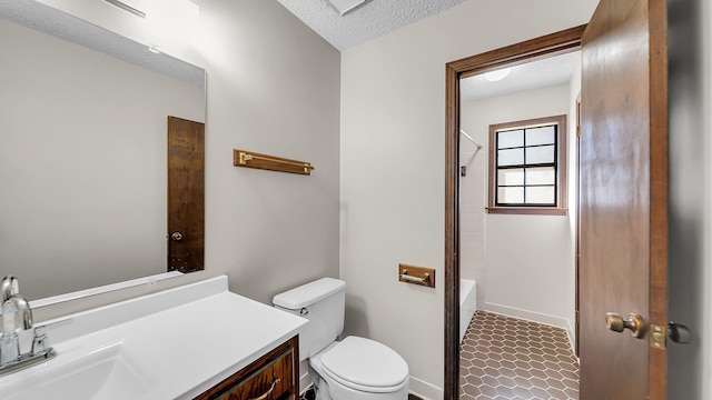 bathroom featuring vanity, a textured ceiling, and toilet