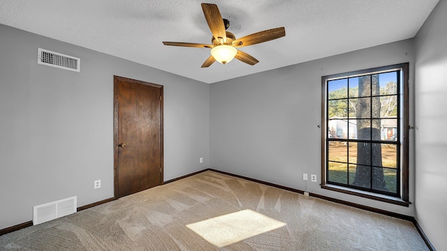 empty room featuring carpet flooring, a textured ceiling, and ceiling fan