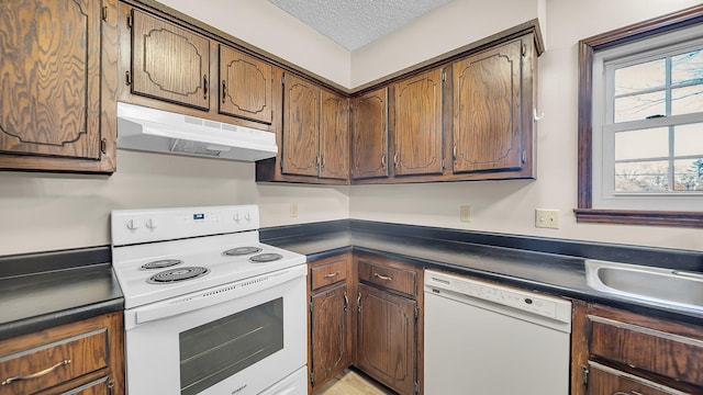 kitchen with a textured ceiling, sink, and white appliances