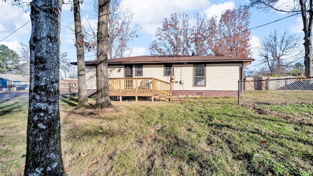 rear view of house featuring a yard and a wooden deck