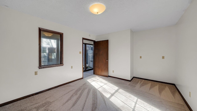 carpeted spare room featuring a textured ceiling