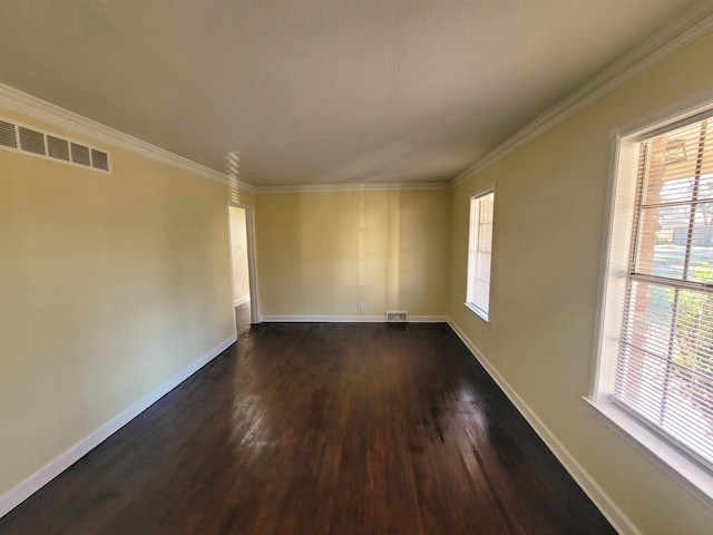 spare room featuring dark hardwood / wood-style floors, a wealth of natural light, and crown molding