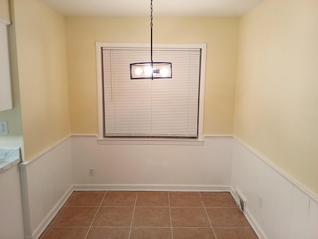 unfurnished dining area with dark tile patterned floors