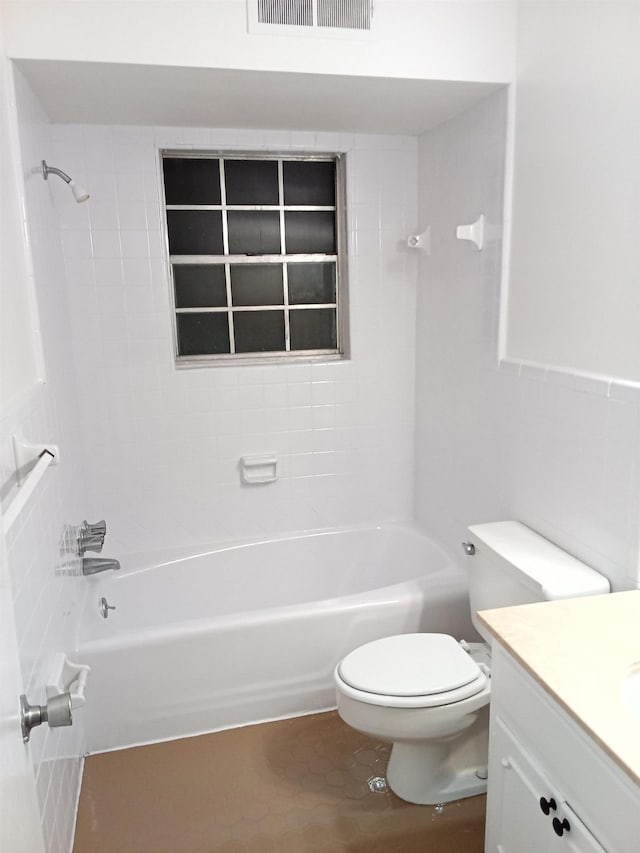 full bathroom featuring vanity, tiled shower / bath combo, and toilet