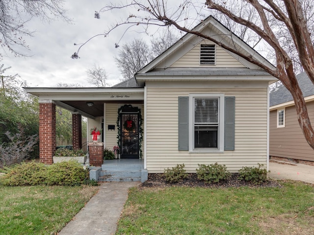 view of front facade featuring covered porch and a front yard