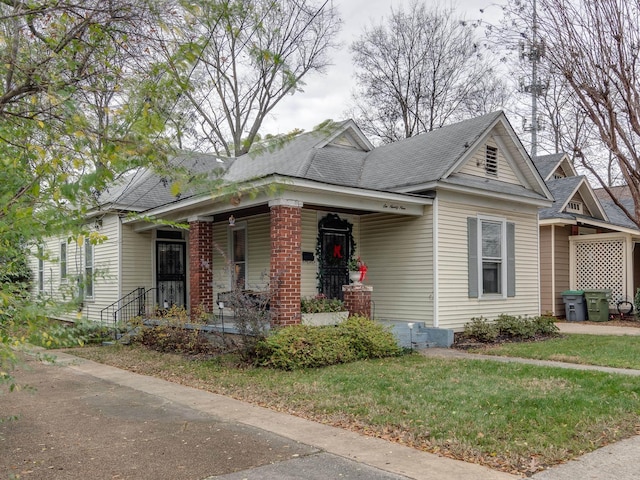 view of front of home with covered porch and a front lawn