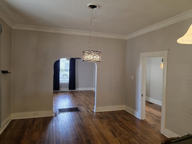 unfurnished dining area with ornamental molding, arched walkways, dark wood-type flooring, and baseboards